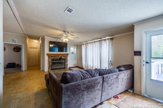22337 Red Sand, San Antonio, TX 78264 - living area featuring a textured ceiling, crown molding, ceiling fan, and a stone fireplace