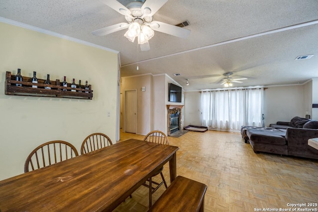 22337 Red Sand, San Antonio, TX 78264 - dining space with a textured ceiling, ceiling fan, a fireplace, and crown molding