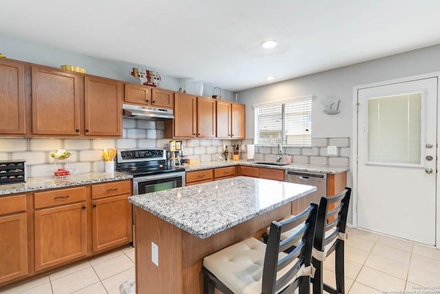 11807 Amber Tree, San Antonio, TX 78254 - kitchen with under cabinet range hood, electric range, a sink, a breakfast bar, and backsplash