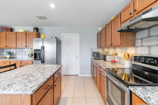 11807 Amber Tree, San Antonio, TX 78254 - kitchen featuring stainless steel appliances, under cabinet range hood, decorative backsplash, light tile patterned floors, and light stone countertops