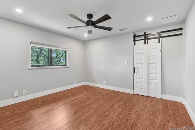 3902 Creek Pt, San Antonio, TX 78230 - unfurnished room with a ceiling fan, wood finished floors, baseboards, recessed lighting, and a barn door