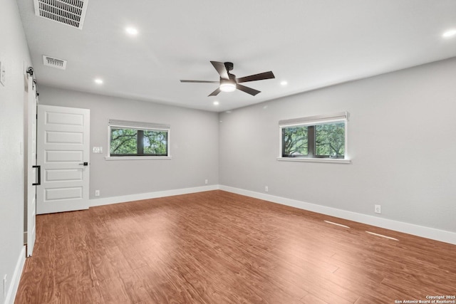 3902 Creek Pt, San Antonio, TX 78230 - empty room with recessed lighting, a ceiling fan, a barn door, wood finished floors, and baseboards