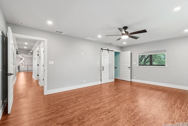 3902 Creek Pt, San Antonio, TX 78230 - unfurnished bedroom with a barn door, recessed lighting, wood finished floors, baseboards, and ceiling fan