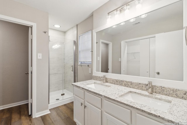 4742 Highland Farm, San Antonio, TX 78244 - full bathroom featuring a stall shower, double vanity, wood finished floors, a spacious closet, and baseboards