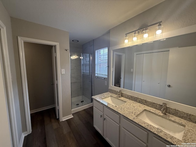 4742 Highland Farm, San Antonio, TX 78244 - bathroom with wood finished floors, a stall shower, double vanity, toilet, and a textured ceiling