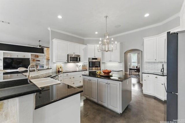810 Pinnacle, New Braunfels, TX 78132 - kitchen featuring stainless steel appliances, concrete flooring, a sink, arched walkways, and decorative backsplash