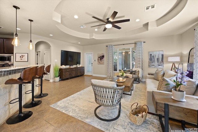 13055 Grove Pt, San Antonio, TX 78253 - living room featuring arched walkways, a raised ceiling, recessed lighting, ceiling fan, and light tile patterned floors