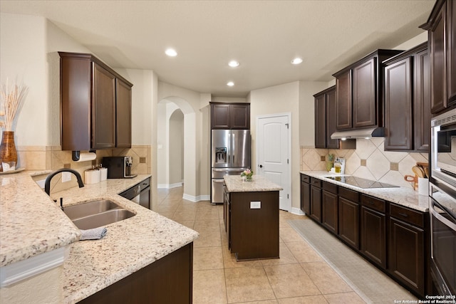 13055 Grove Pt, San Antonio, TX 78253 - kitchen with appliances with stainless steel finishes, a sink, arched walkways, light stone counters, and recessed lighting