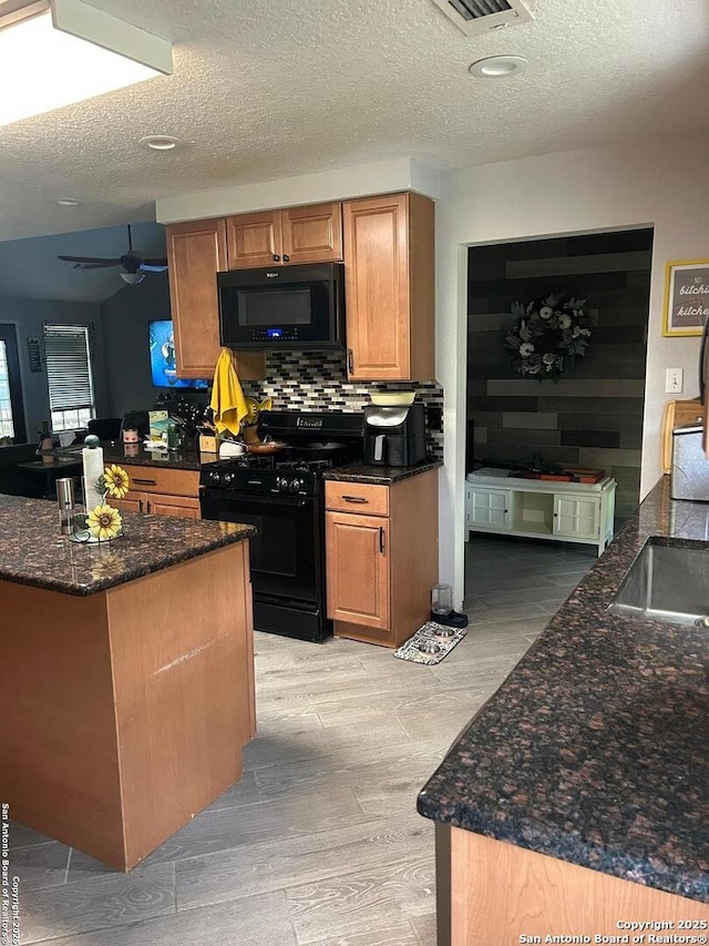 129 W High Line, Trinity, TX 75862 - kitchen with black appliances, ceiling fan, tasteful backsplash, dark stone countertops, and a textured ceiling