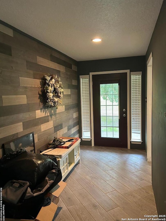 129 W High Line, Trinity, TX 75862 - doorway to outside featuring wood walls, a textured ceiling, wood-type flooring, an accent wall, and recessed lighting