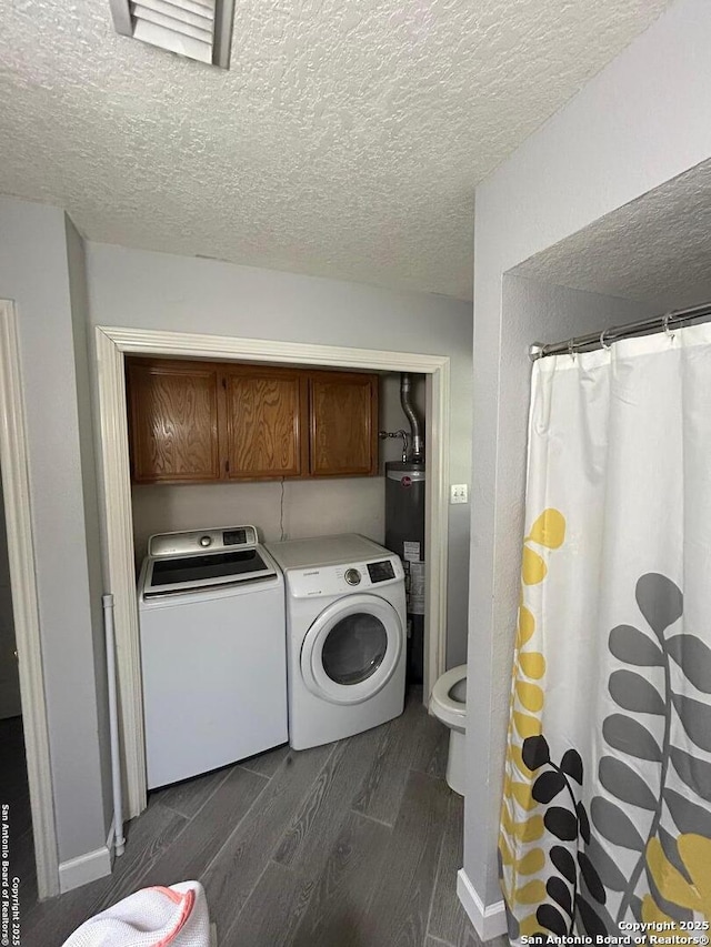 129 W High Line, Trinity, TX 75862 - laundry area featuring washing machine and clothes dryer, wood finish floors, a textured ceiling, water heater, and cabinet space