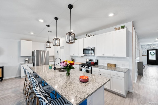 5483 Jasmine, Bulverde, TX 78163 - kitchen featuring appliances with stainless steel finishes, a sink, light wood-type flooring, baseboards, and a kitchen bar
