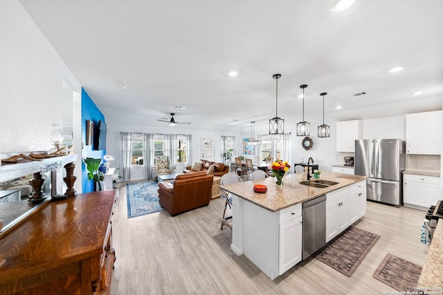 5483 Jasmine, Bulverde, TX 78163 - kitchen with appliances with stainless steel finishes, a sink, open floor plan, recessed lighting, and light wood-type flooring