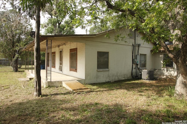 1413 Martin, Pleasanton, TX 78064 - view of side of home featuring a lawn, concrete block siding, central AC unit, and a patio