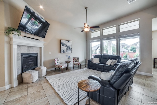 2023 Wilby Ln, San Antonio, TX 78253 - living room featuring a fireplace, a ceiling fan, baseboards, light tile patterned floors, and a towering ceiling