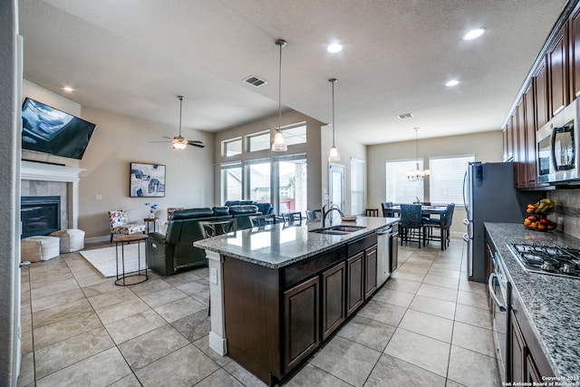 2023 Wilby Ln, San Antonio, TX 78253 - kitchen featuring stainless steel appliances, a sink, a fireplace, light tile patterned floors, and recessed lighting