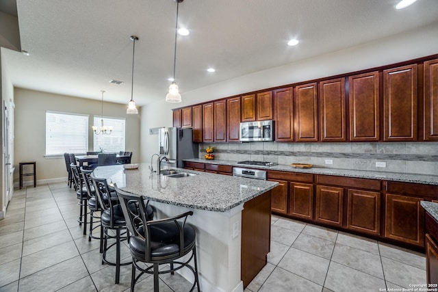 2023 Wilby Ln, San Antonio, TX 78253 - kitchen featuring appliances with stainless steel finishes, a sink, an island with sink, light tile patterned flooring, and recessed lighting