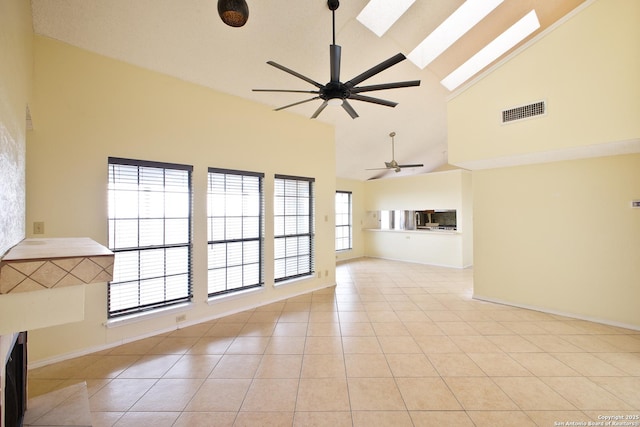 6100 Woodlake Pkwy Unit 706, San Antonio, TX 78244 - unfurnished living room with a ceiling fan, high vaulted ceiling, a skylight, light tile patterned floors, and baseboards