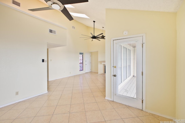 6100 Woodlake Pkwy Unit 706, San Antonio, TX 78244 - spare room featuring a ceiling fan, vaulted ceiling, a skylight, light tile patterned floors, and baseboards