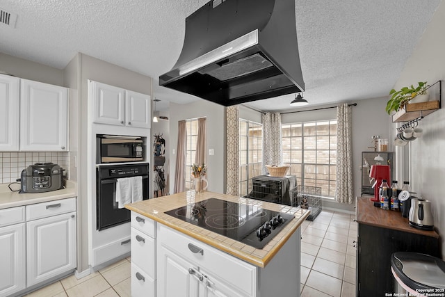 4303 Lakebend W, San Antonio, TX 78244 - kitchen with black appliances, ventilation hood, a textured ceiling, light tile patterned floors, and white cabinetry