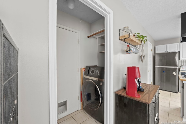 4303 Lakebend W, San Antonio, TX 78244 - laundry room with washer / dryer, light tile patterned floors, and a textured ceiling