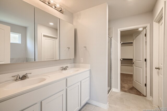 4823 Swing Arc, San Antonio, TX 78261 - bathroom with a stall shower, double vanity, tile patterned floors, a walk in closet, and recessed lighting