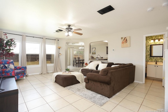 9011 Twincreek Farm, Converse, TX 78109 - living room with arched walkways, a ceiling fan, light tile patterned floors, and baseboards