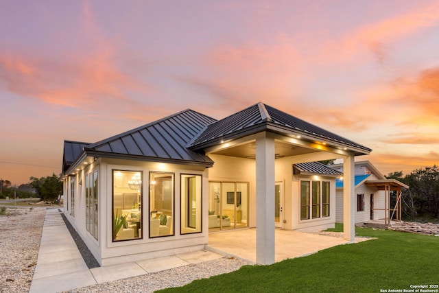 1475 Echo Mdw, Spring Branch, TX 78070 - rear view of house featuring a standing seam roof, metal roof, a patio, and a lawn