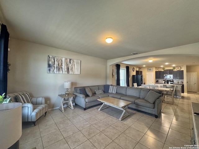 5726 Ivans Farm, San Antonio, TX 78244 - living room featuring light tile patterned floors, arched walkways, and baseboards