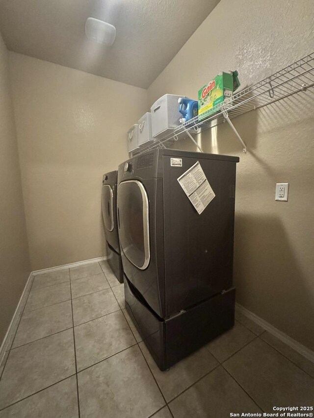 5726 Ivans Farm, San Antonio, TX 78244 - laundry area with independent washer and dryer, light tile patterned floors, baseboards, and a textured wall