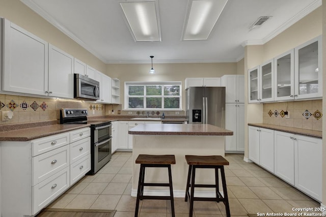 141 Rio Grande, Seguin, TX 78155 - kitchen with appliances with stainless steel finishes, white cabinetry, decorative backsplash, a center island, and glass insert cabinets