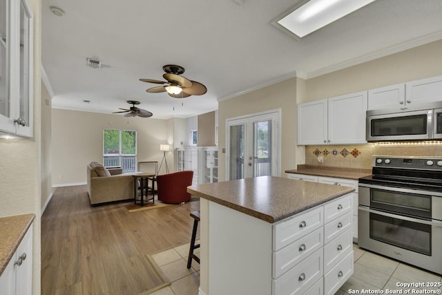 141 Rio Grande, Seguin, TX 78155 - kitchen with appliances with stainless steel finishes, crown molding, tasteful backsplash, a kitchen breakfast bar, and open floor plan