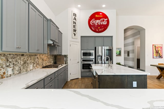 9730 Kremmen, Boerne, TX 78006 - kitchen with stainless steel appliances, arched walkways, gray cabinetry, under cabinet range hood, and recessed lighting