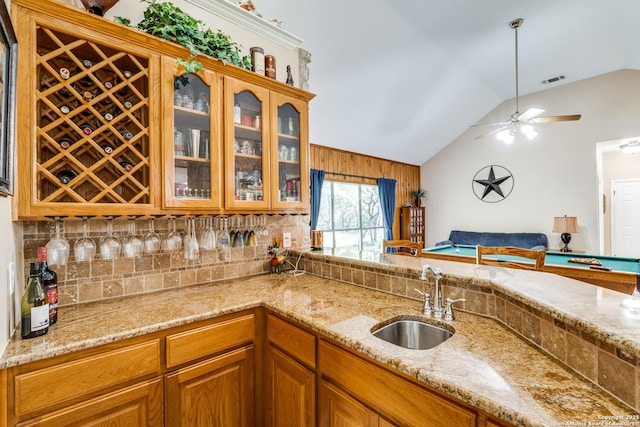 31763 Scarteen, Fair Oaks Ranch, TX 78015 - kitchen featuring a sink, lofted ceiling, tasteful backsplash, glass insert cabinets, and light stone countertops
