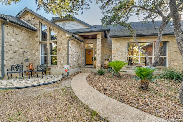 31763 Scarteen, Fair Oaks Ranch, TX 78015 - doorway to property featuring stone siding, a patio, and a shingled roof