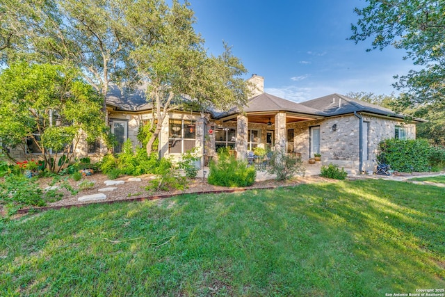31763 Scarteen, Fair Oaks Ranch, TX 78015 - view of front facade with ceiling fan, a chimney, a front yard, and stone siding