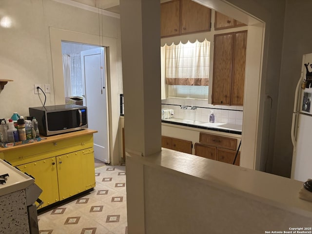 1927 Lee Hall, San Antonio, TX 78201 - kitchen featuring stainless steel microwave, freestanding refrigerator, tasteful backsplash, and tile countertops