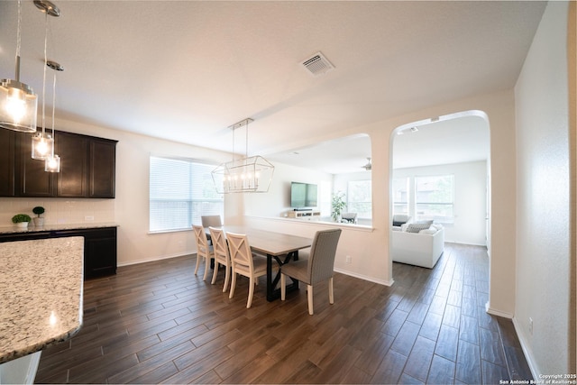 7207 Independence Way, San Antonio, TX 78223 - dining space featuring dark wood-style flooring, arched walkways, baseboards, and a chandelier