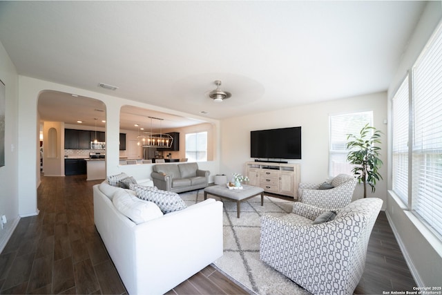 7207 Independence Way, San Antonio, TX 78223 - living room featuring dark wood-type flooring, a chandelier, and arched walkways