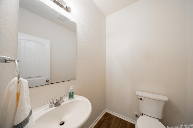 7207 Independence Way, San Antonio, TX 78223 - bathroom featuring wood finished floors, toilet, a sink, and baseboards