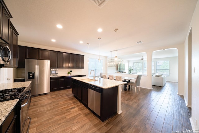 7207 Independence Way, San Antonio, TX 78223 - kitchen featuring stainless steel appliances, a sink, wood finished floors, recessed lighting, and light stone counters