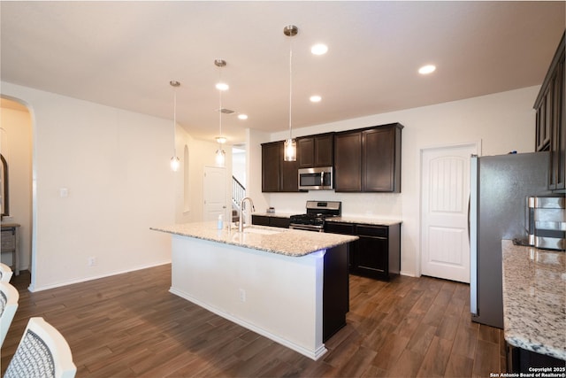 7207 Independence Way, San Antonio, TX 78223 - kitchen featuring stainless steel appliances, a sink, arched walkways, dark wood-style floors, and dark brown cabinets