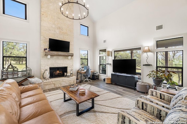 159 Inspiration, Fredericksburg, TX 78624 - living room featuring high vaulted ceiling, a chandelier, a fireplace, and wood finished floors