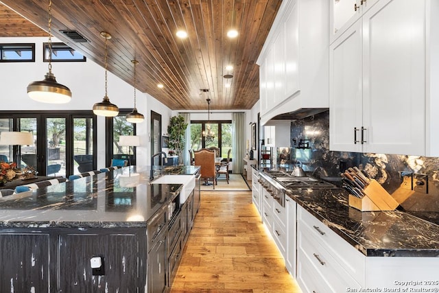 159 Inspiration, Fredericksburg, TX 78624 - kitchen with wood ceiling, a sink, french doors, a large island, and light wood-style floors