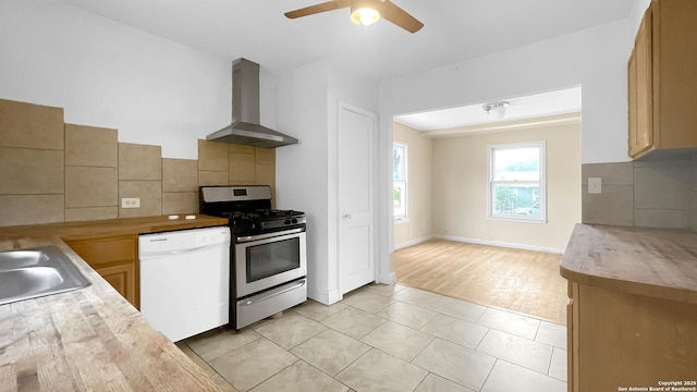 310 Merry Ann, San Antonio, TX 78223 - kitchen featuring wall chimney range hood, gas range, white dishwasher, light countertops, and ceiling fan