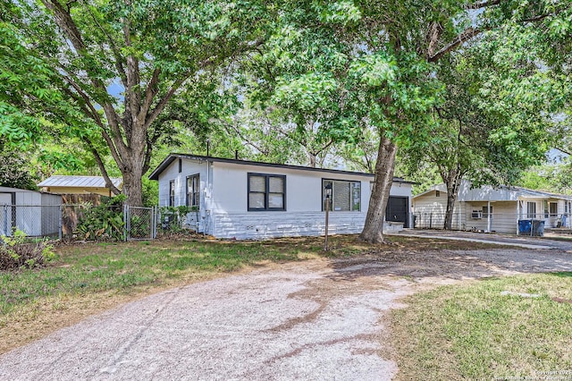 258 S Live Oak, New Braunfels, TX 78130 - single story home featuring stone siding, dirt driveway, a garage, and a gate