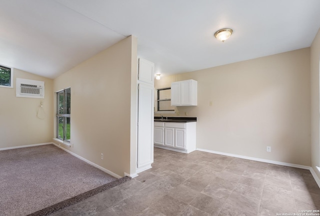 4863 Castle Shield, San Antonio, TX 78218 - unfurnished living room featuring healthy amount of natural light, a wall mounted air conditioner, a sink, baseboards, and vaulted ceiling
