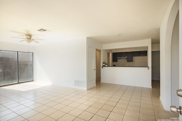 3258 Twining, San Antonio, TX 78211 - empty room featuring ceiling fan, light tile patterned flooring, arched walkways, and baseboards