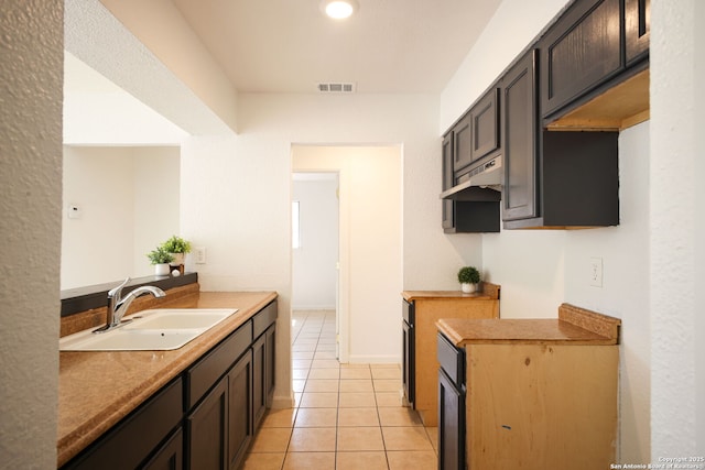 3258 Twining, San Antonio, TX 78211 - kitchen featuring a sink, light tile patterned flooring, under cabinet range hood, and baseboards