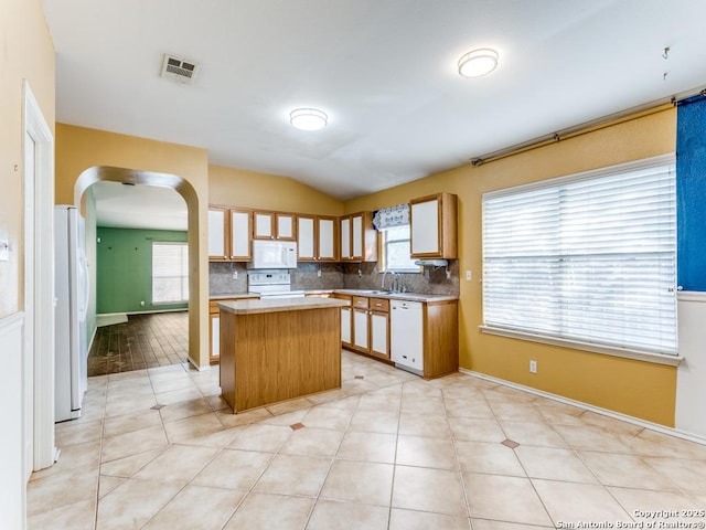 14342 Markham Ln, San Antonio, TX 78247 - kitchen featuring white appliances, a center island, arched walkways, lofted ceiling, and a sink